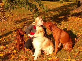 Ninnie Ohlsson with dogs in autumn leaves